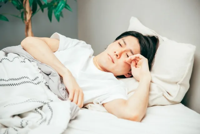 眠いけど眠れない男性のイメージ画像
