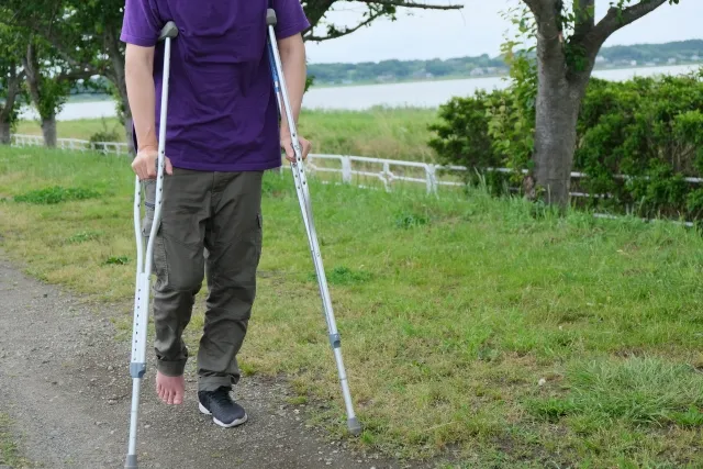 根本治療の定義。けがした松葉づえの男性の写真。