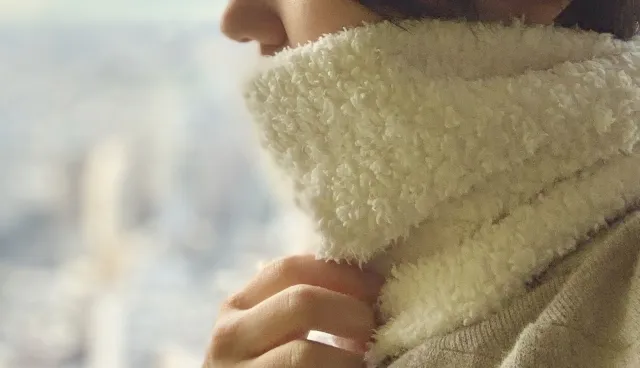 冷え症の女性が春にネックウォーマーをしている様子