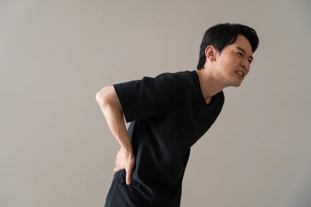 腰を痛めたギックリ腰の可能性もある男性の写真