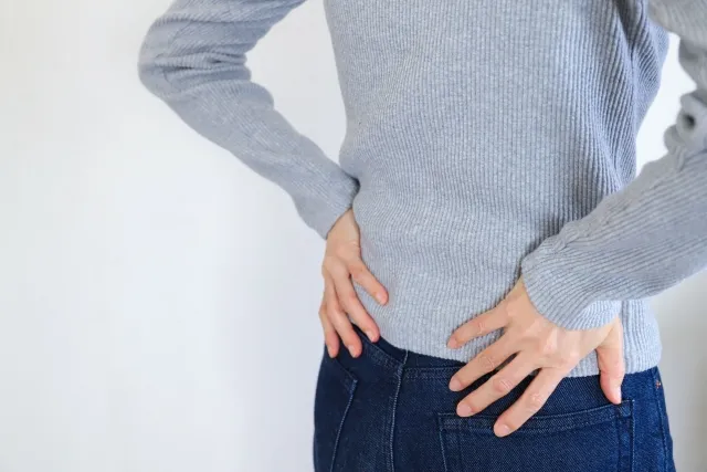 慢性腰痛を感じた女性の姿