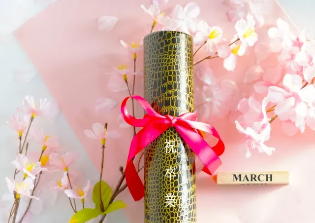 卒業証書の筒と桜の卒業のイメージ写真