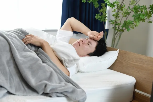 ストレスにより自律神経が乱れ睡眠不足の男性の写真