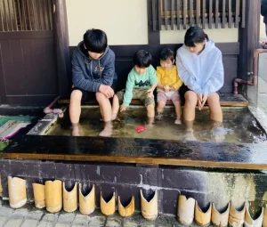 子供が仲良く足湯している様子